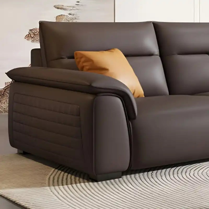 dark brown luxury sofa with broad pillow soft arms, cushioned back and detailed side panels — side angle showing the arms...