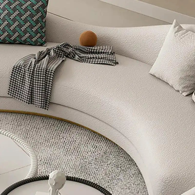 off white curved sofa with deep cushions, smooth rounded arms and soft textured fabric — close view showing the cushion an...