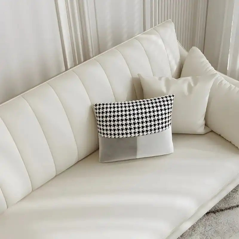soft cream corner sofa with deep cushions, vertical back details and slim gold finish legs — close view showing the cushio...