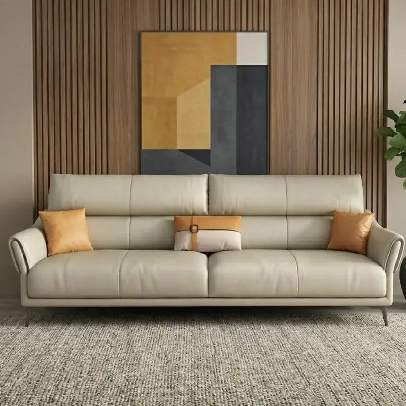 beige leatherette sofa with supportive high back cushions, rounded arms and slim raised legs — close view showing the cush...