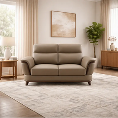beige pure leather sofa with supportive back cushions, curved arms and refined wooden details — wide room view showing the...