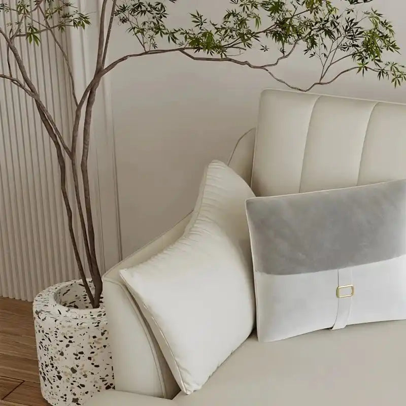 soft cream corner sofa with deep cushions, vertical back details and slim gold finish legs — wide room view showing the co...