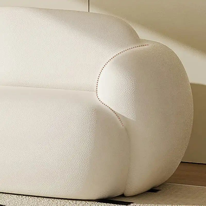 soft curved fabric sofa with cloud like cushions, wraparound arms and a low grounded base — wide room view showing the com...