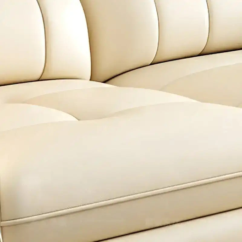 cream high back sofa with vertical cushion panels, rounded arms and slim gold finish legs — wide room view showing the com...