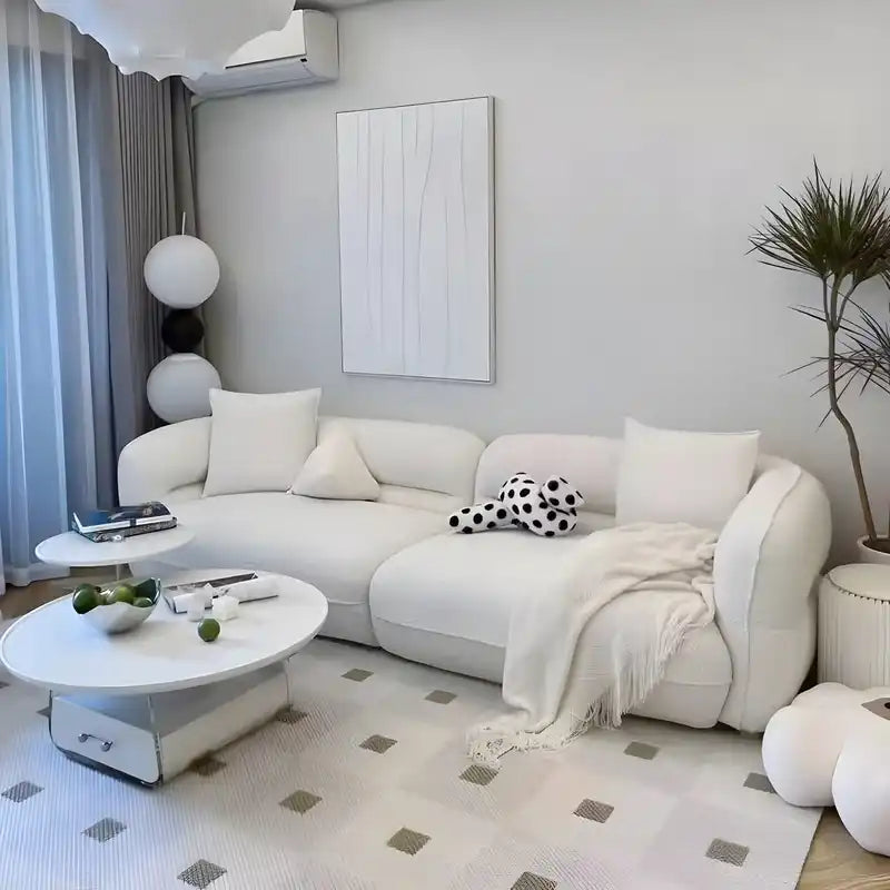 low lounge sofa with thick cushions, loose back pillows and soft rounded edges — wide room view showing the complete seati...