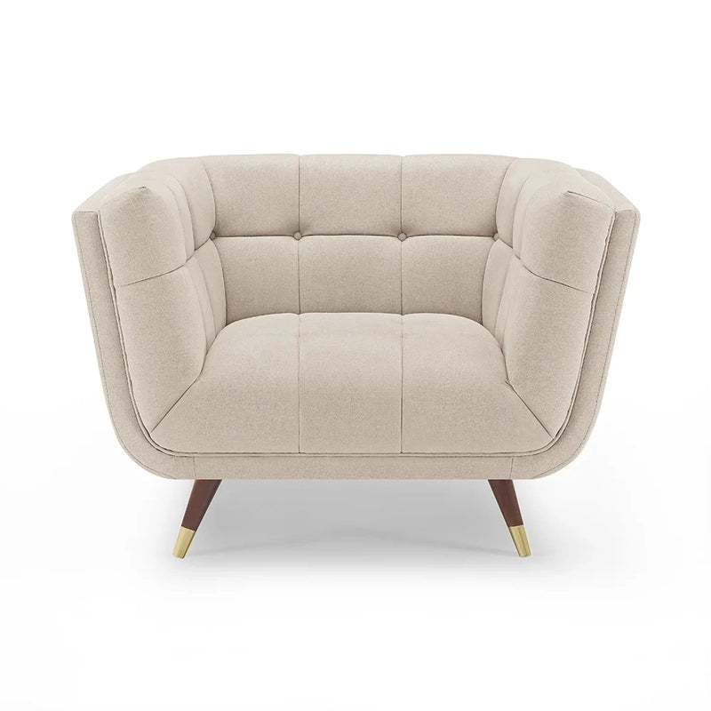 beige fabric sofa with soft curved arms, square cushion details and raised wooden legs — wide room view showing the comple...