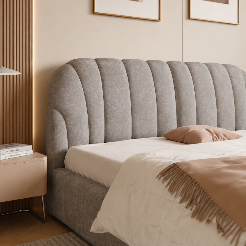 Hambo is a soft grey upholstered bed for Queen size use, shaped with a tall rounded headboard, vertical