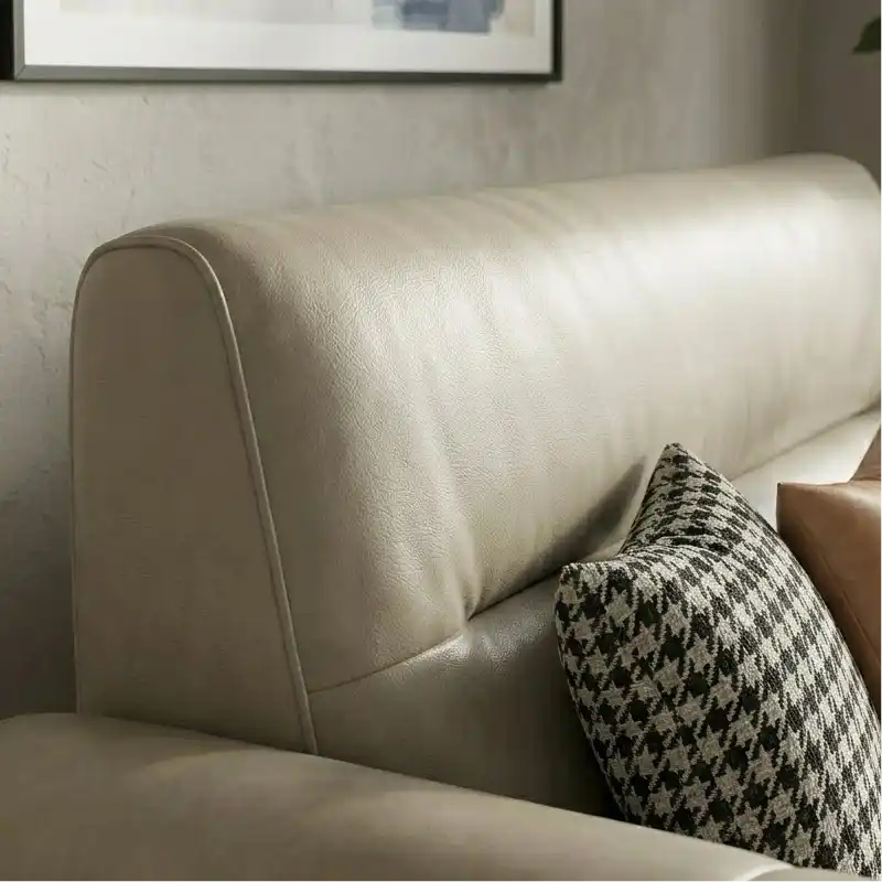 wide leatherette sofa with deep square cushioning and a low relaxed shape — front angle showing the back support and arm s...