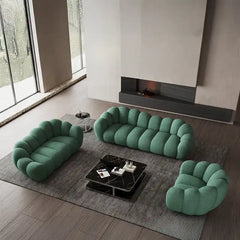 soft curved sofa with rounded cushion sections, a cloud like shape and a low relaxed base — front angle showing the back s...