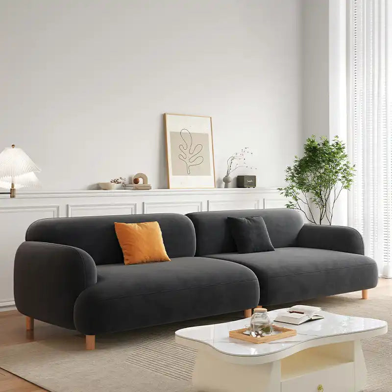 rounded fabric sofa with deep cushions, soft wide arms and a clean modern finish — front angle showing the back support an...