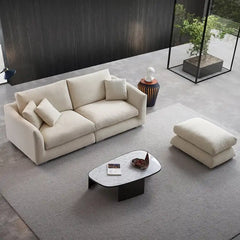 wide l shape fabric sofa with rounded arms, loose back cushions and deep comfortable seating — front angle showing the bac...
