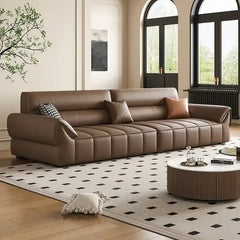 wide leatherette sofa with deep square cushioning and a low relaxed shape — alternate angle showing the full depth and com...