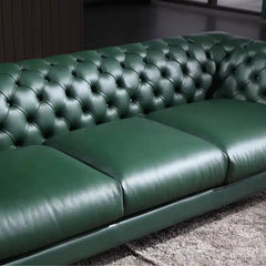 classic dark faux leather sofa with deep button details, high back and broad supportive arms — alternate angle showing the...