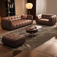 warm brown luxury sofa with deep square cushioning, rounded edges and a low relaxed shape — alternate angle showing the fu...
