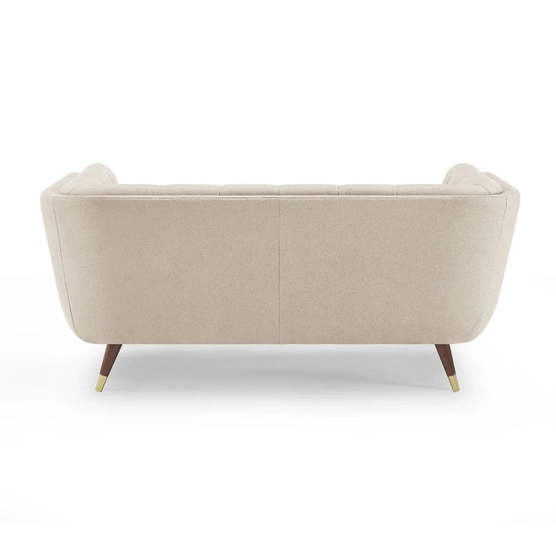 beige fabric sofa with soft curved arms, square cushion details and raised wooden legs — alternate angle showing the full...