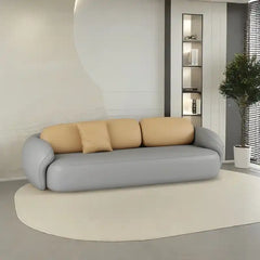 soft curved fabric sofa with cloud like cushions, wraparound arms and a low grounded base — full view with the complete sh...
