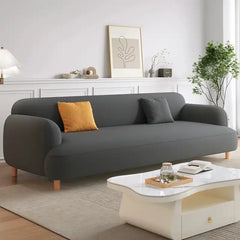 rounded fabric sofa with deep cushions, soft wide arms and a clean modern finish — close view showing the colour and mater...